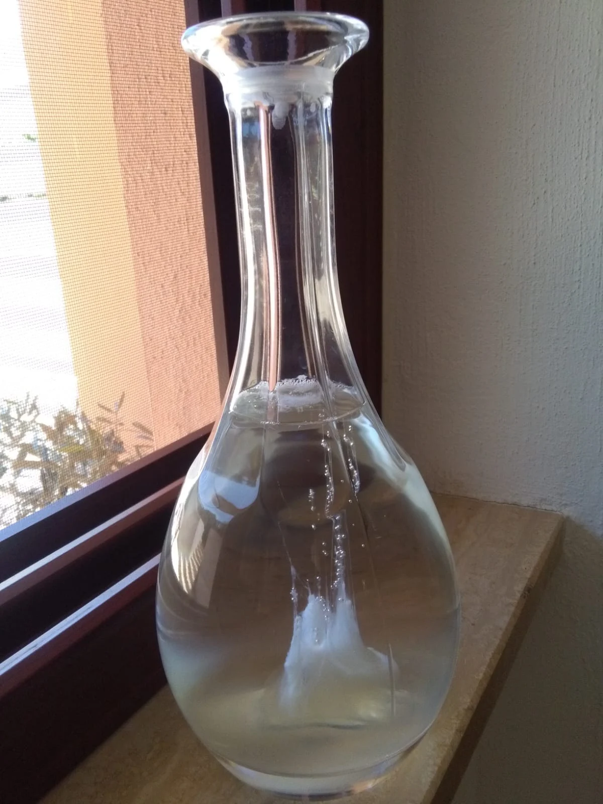 Egg white inside a pitcher of water with a long neck creates the shape of a boat with sails