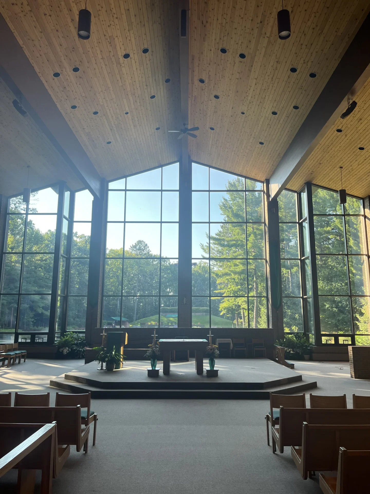Chapel windows facing cross in the woods