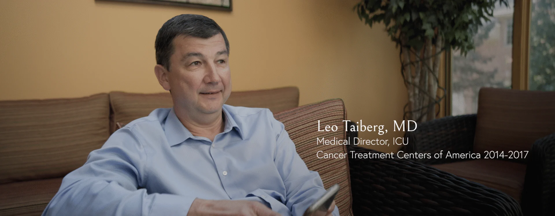 Still from the film with a man sitting down.  There are words which reads: "Leo Taiberg, MD / Medical Director, ICU / Cancer Treatment Centers of America 2014-2017"